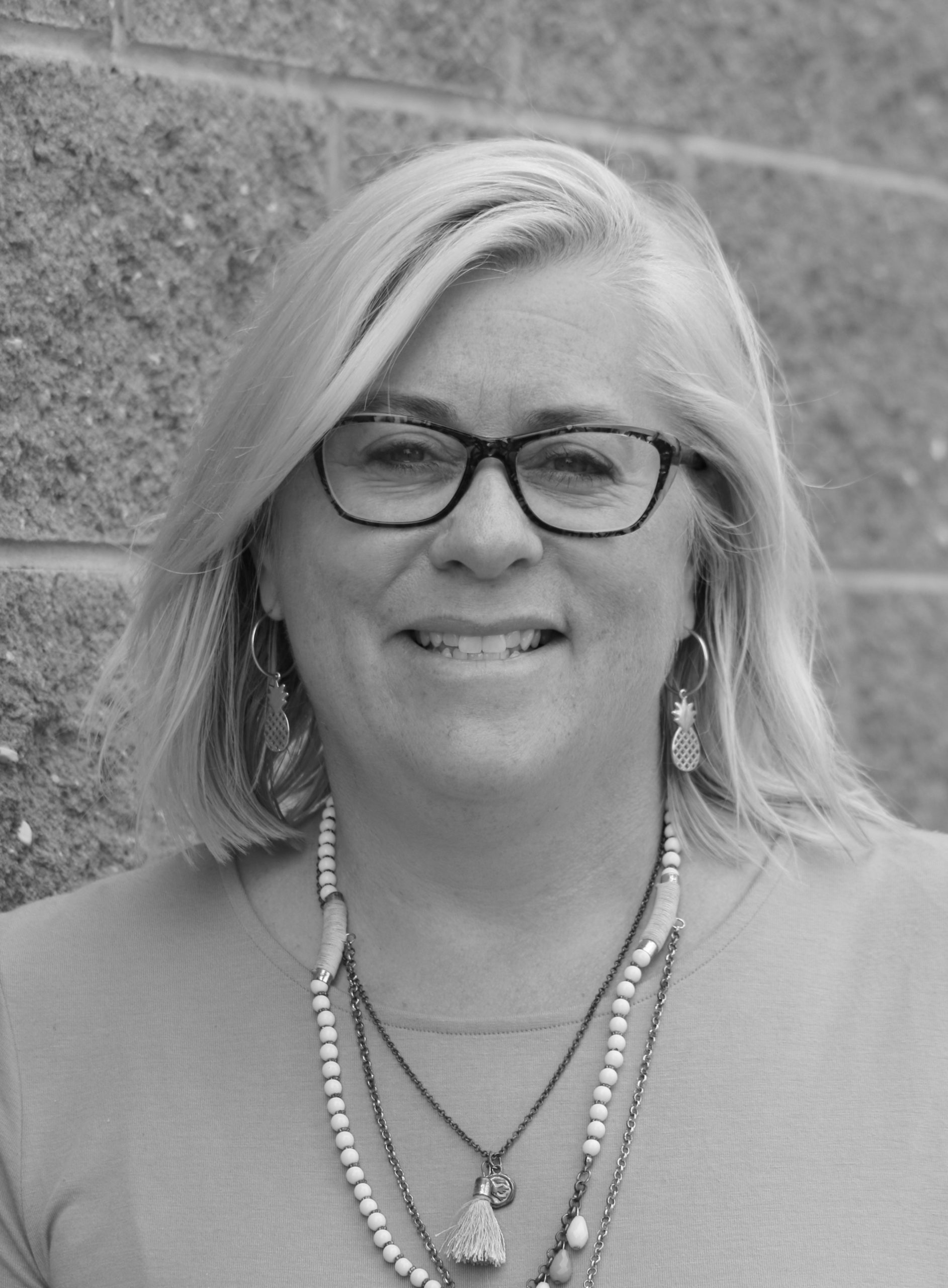 Photo of woman with big smile, glasses, and shoulder length blonde hair